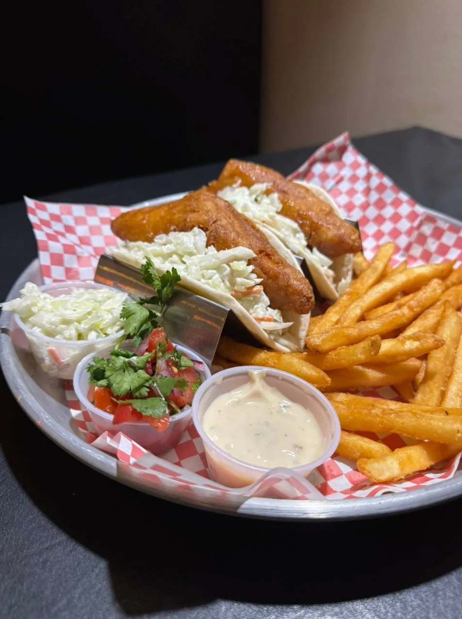 Beer-battered fish tacos with fries, slaw and pico on a checkered liner